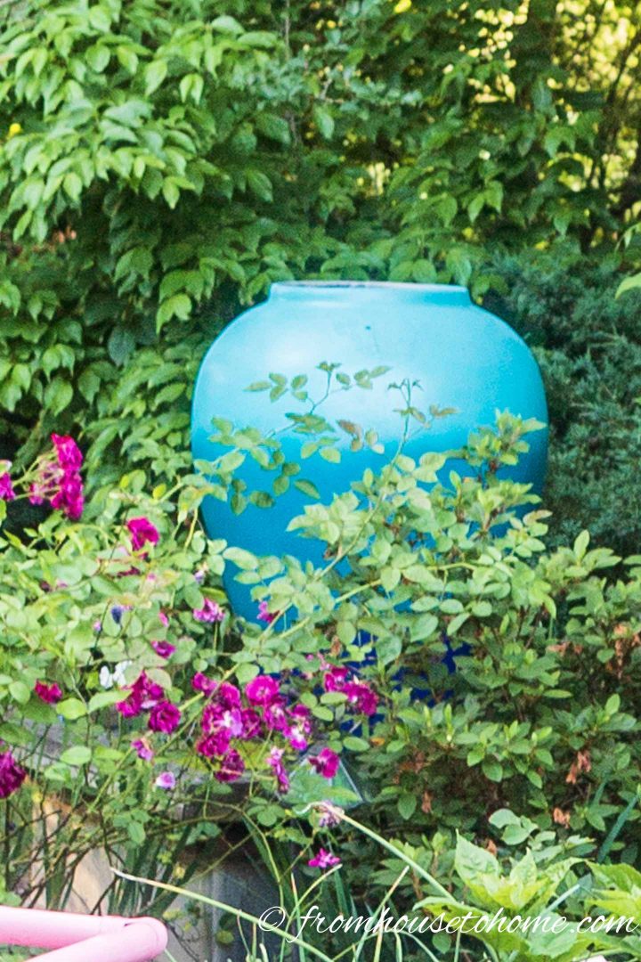 A large blue urn in the middle of the garden