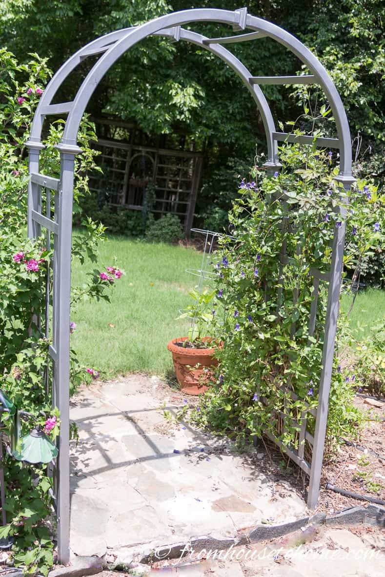 This arbor was originally white plastic...a little spray paint makes it look like metal | 10 Tips For Creating A Low Maintenance Garden