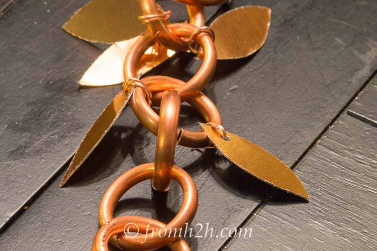 The rain chain with copper leaves attached to either side of it