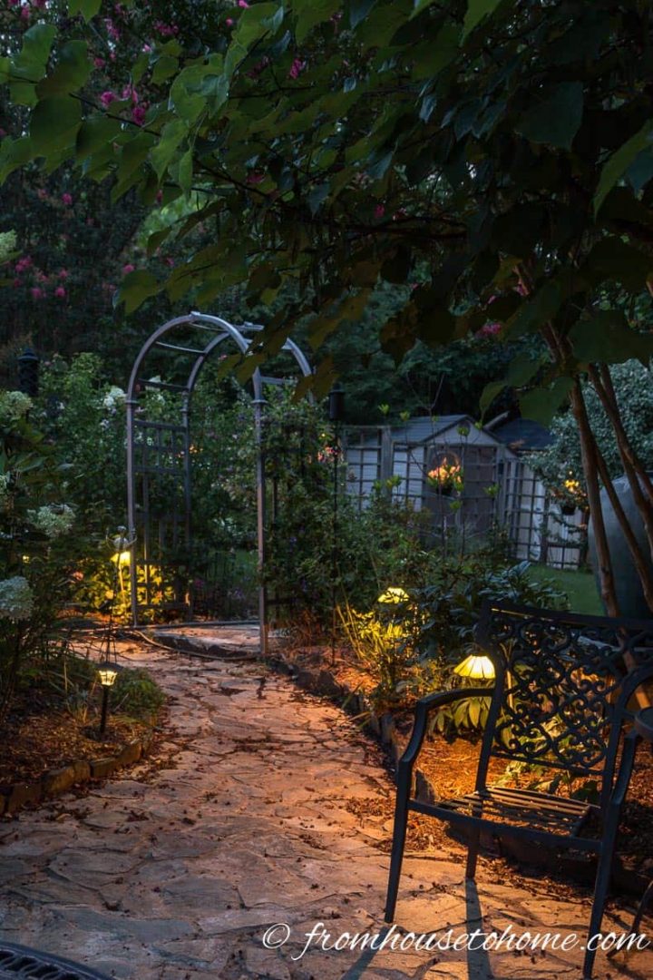 Landscape lighting in a backyard secret garden at night