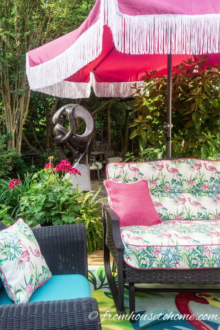 Patio umbrella with fringe over an outdoor sofa and chair