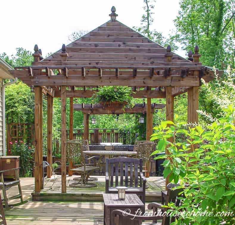 Open air gazebo providing backyard shade over an outdoor dining table on a deck