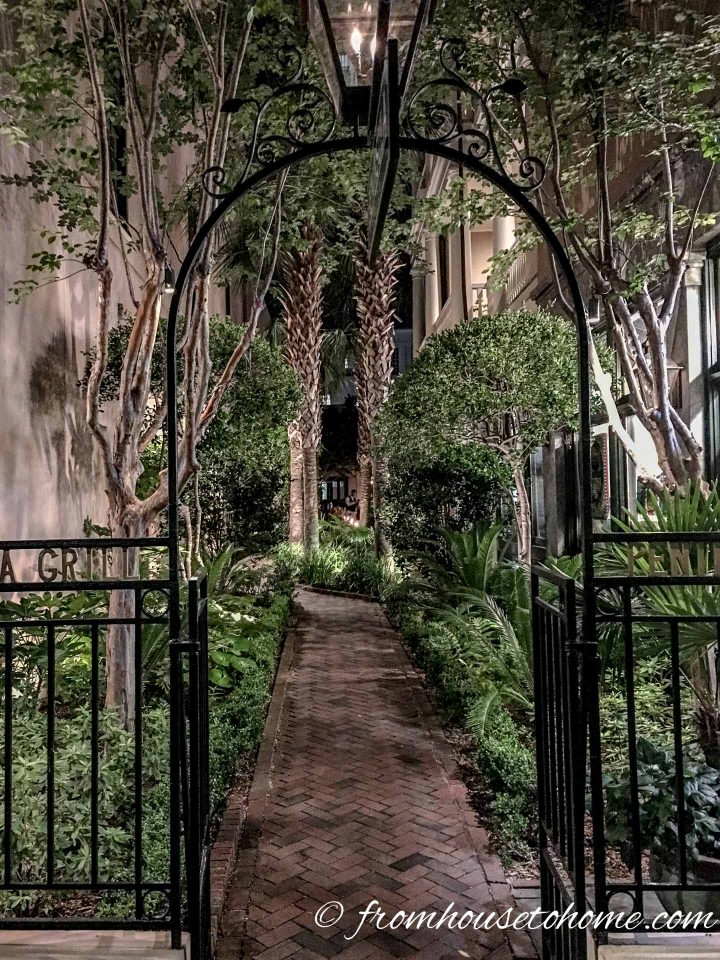 An arbor leading into a secret garden lit up at night