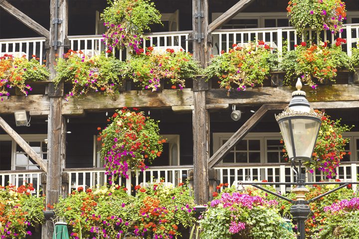 Traditional hanging baskets and window boxes on front porch