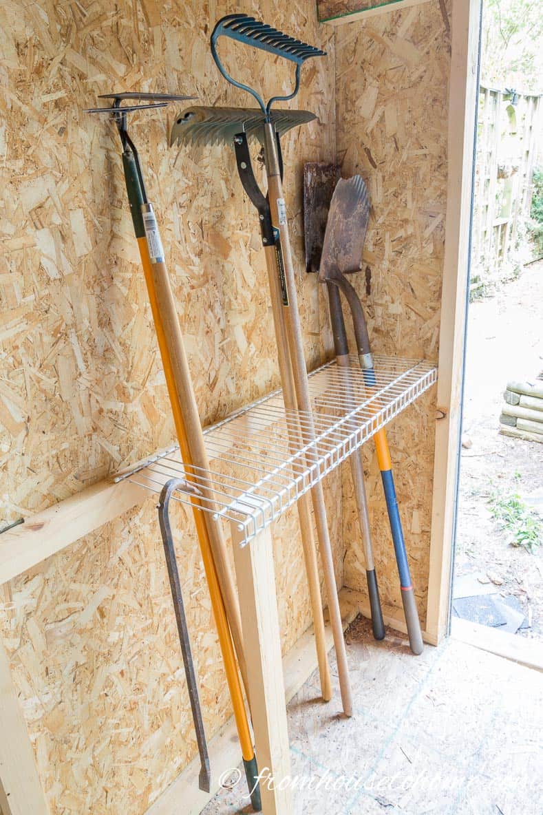 Wire shelves for garden tool storage like rakes and shovels