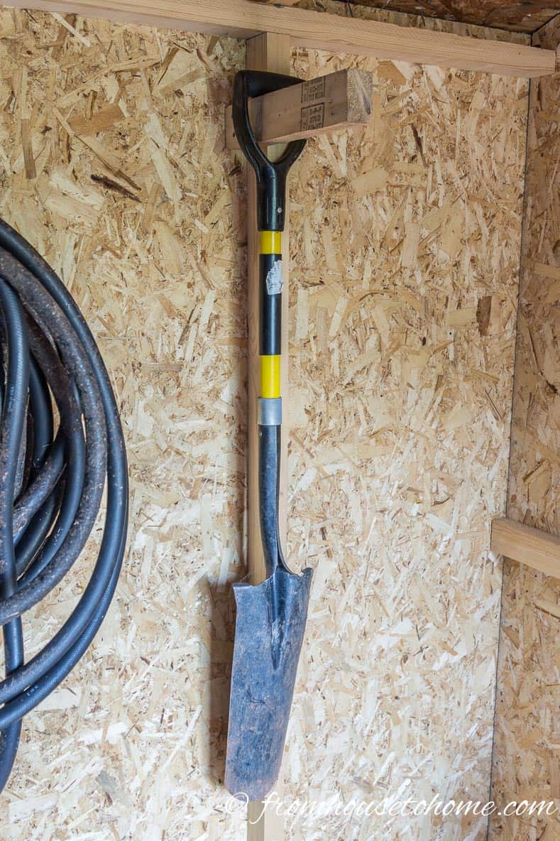 Shovel hung on a 2" x 4" in a shed
