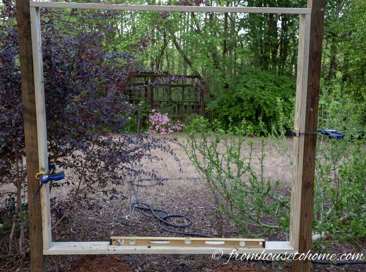 Both sides of the privacy screen frame secured to posts with clamps and made straight with a level