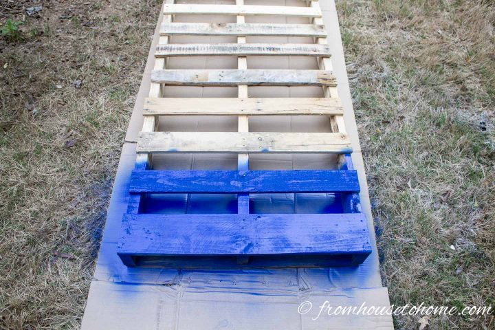 Bottom two slats of a pallet painted blue