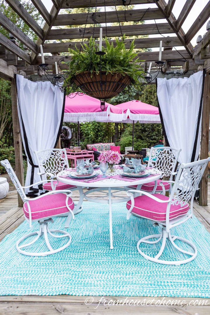 Gazebo with curtains and a pink and turquoise table setting
