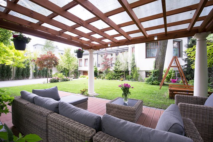 Pergola with plastic roof panels covering brick patio