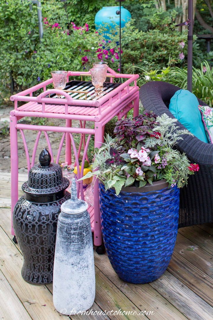 Outdoor bar cart, large vases and a blue container on a deck