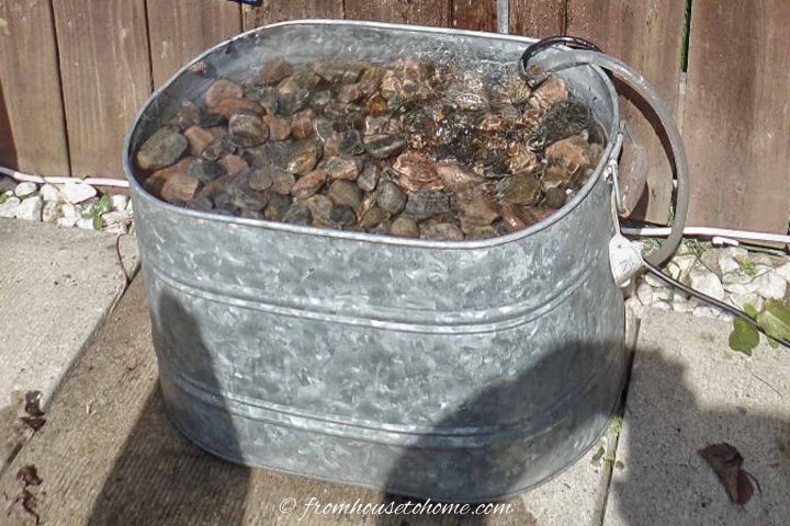 Galvanized tub filled with rocks as the bottom of a fountain