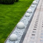 modern gravel garden edging with round concrete balls down the middle