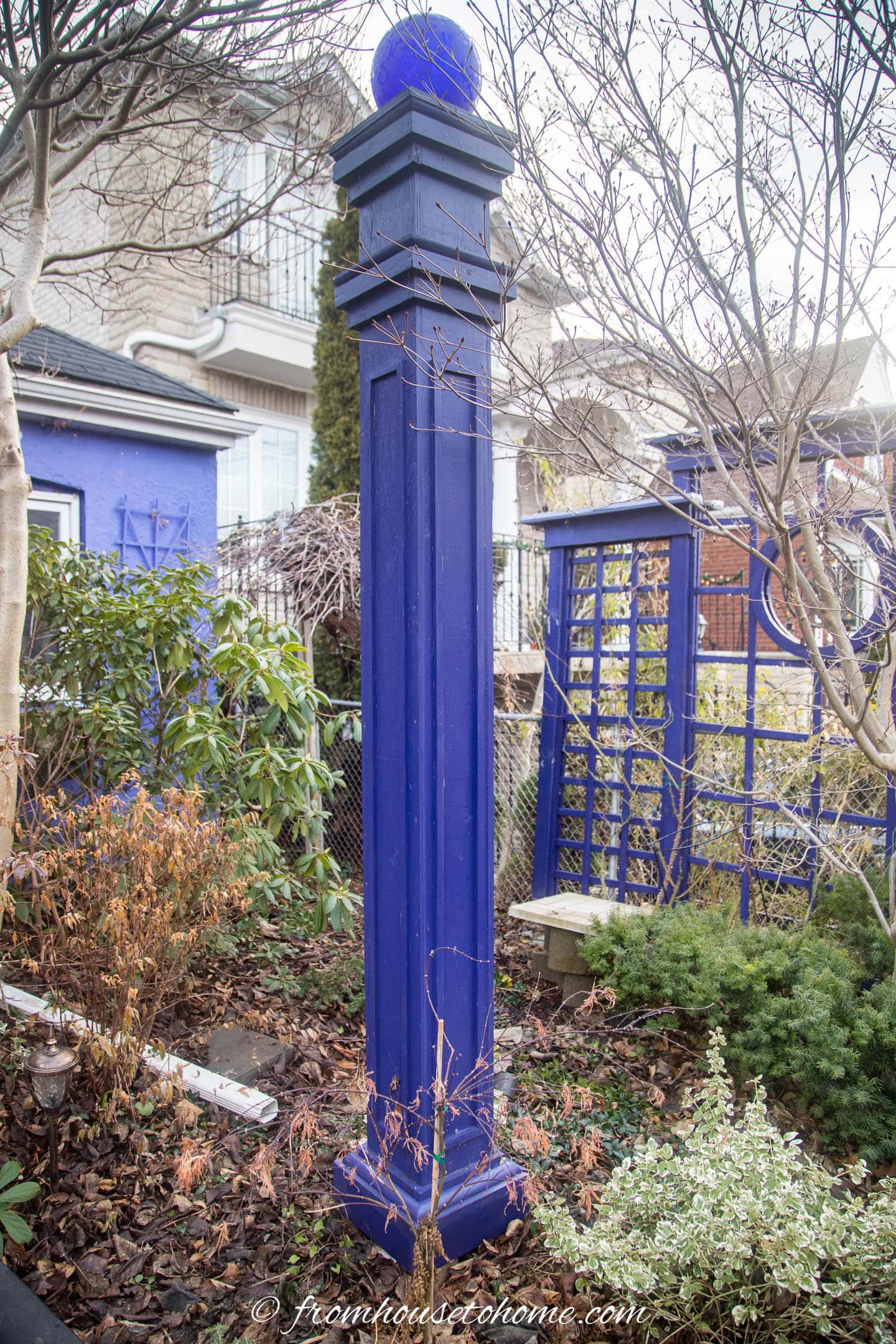 blue gazing globe on top of a tall pedestal in a garden