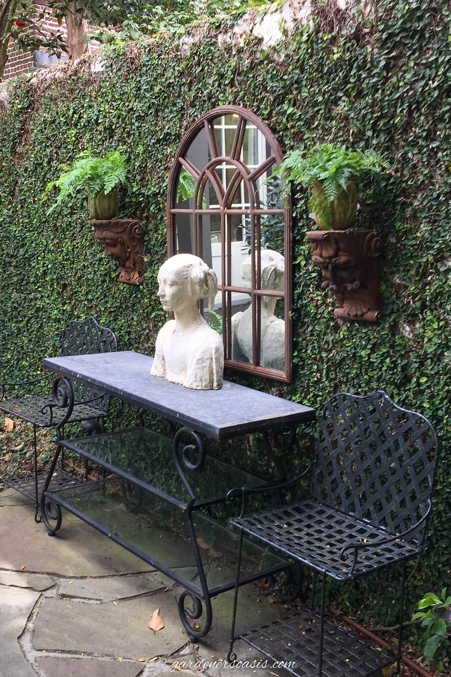 Secret garden decorations including an outdoor mirror, console table, statue and wall sconces