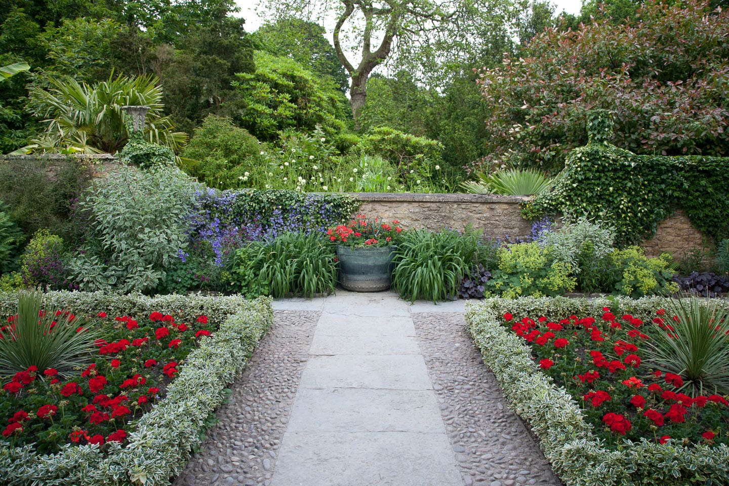 A formal garden with square gardens on each side of a central path