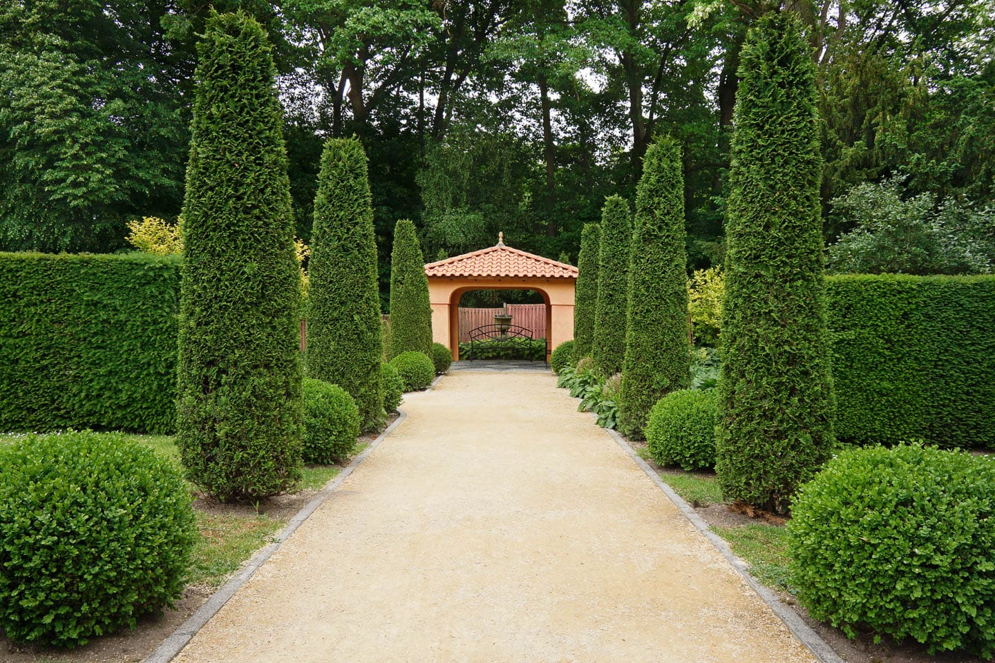 Italian symmetrical garden with a central path leading to a pergola