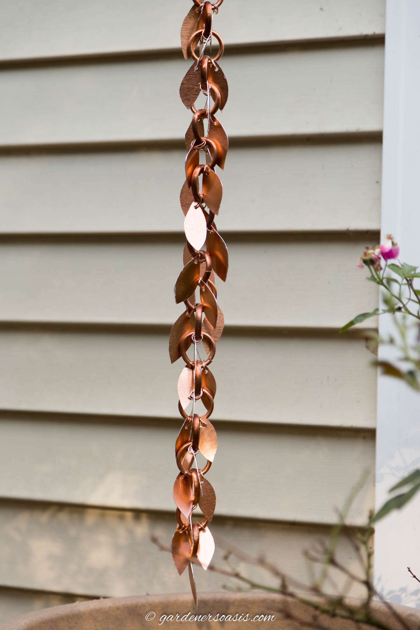 DIY copper link rain chain with copper leaves attached to it