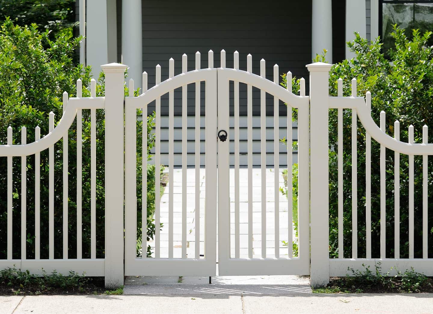A white picket fence in front of a house.